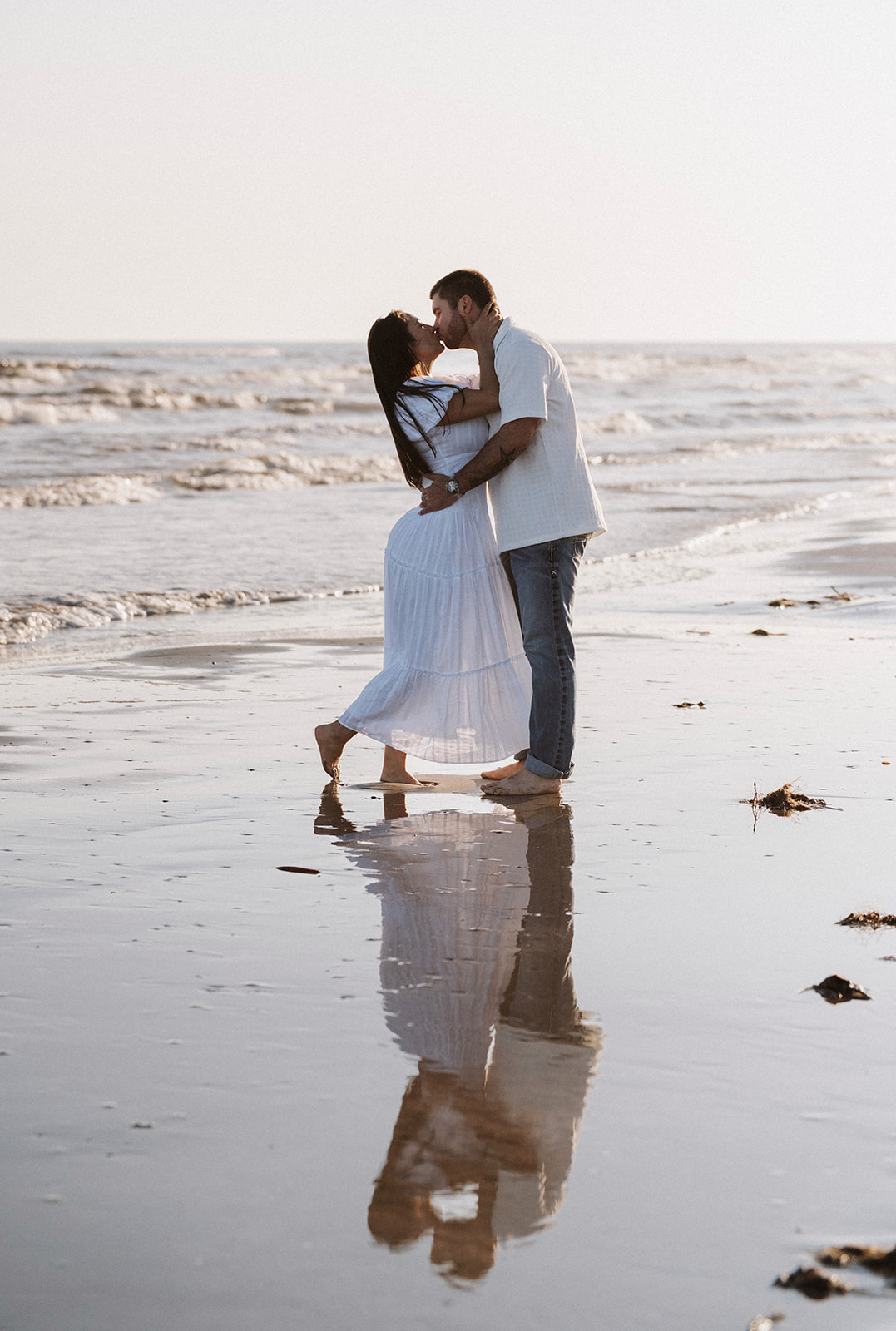 Couple kissing on the beach at sunset