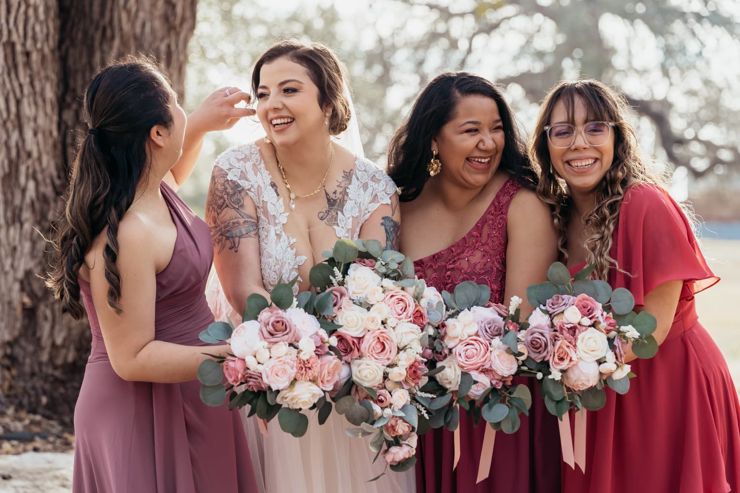 Bride laughing with her bridesmaids and bouquets