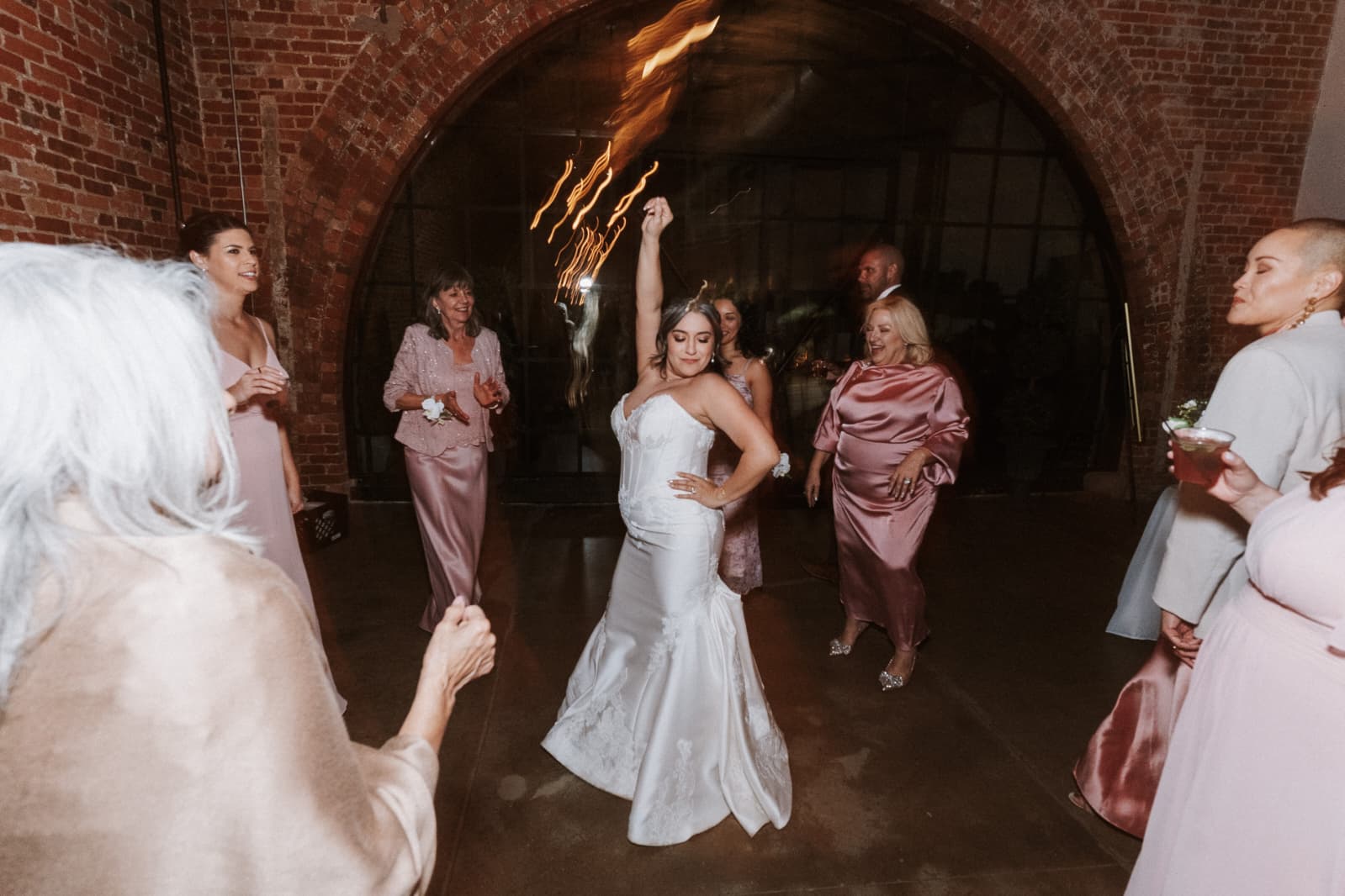 Bride dancing with family at the reception