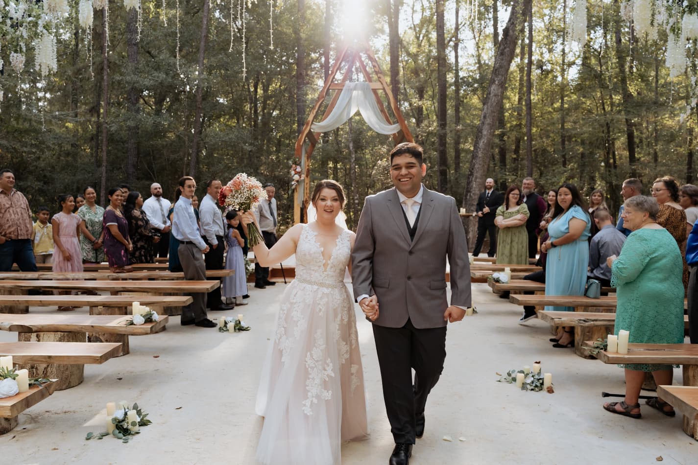 Couple walking down the aisle in the woods